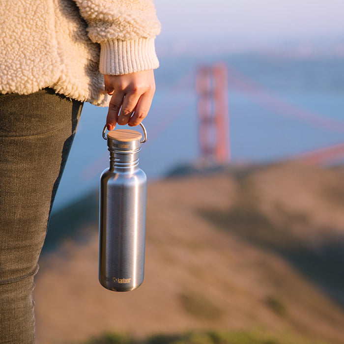 27oz-reflect-with-bamboo-cap-l6 K27SSLRF-BS-BAMBOO_reflect_bottle_bridge_lifestyle.jpg
